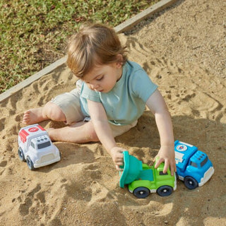 Child playing with toy cars in a sandbox
