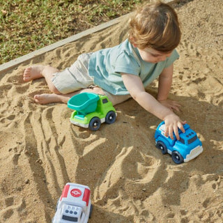 Child playing with toy cars in a sandpit