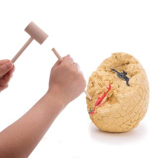 hands digging for dinosaurs in a clay egg