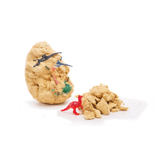 Playful arrangement of sandcastles with toy dinosaurs on a white background