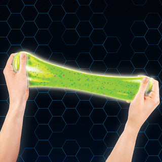 Green gel-like substance being stretched between two hands against a dark background with a hexagonal pattern.