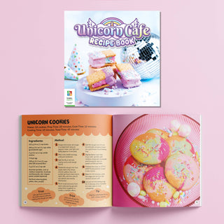  unicorn cafe recipe book with unicorn cookies on a pink background
